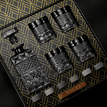 Whiskey decanter gift set featuring a stylish black decanter, four matching glasses, and chilling stones for the perfect barware.