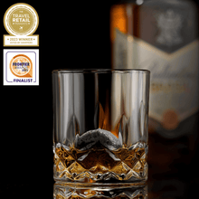Whiskey glass filled with amber spirit and chilling stone, showcasing the Connoisseur's Set for an elegant drinking experience.