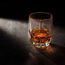 Elegant crystal whiskey glass with amber bourbon, showcasing eco-friendly glass craftsmanship.