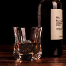Twist glass with whiskey and a bottle of Yamazaki single malt, featuring whiskey chilling stones for the perfect drink.