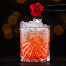 Cocktail served in a crystal whiskey glass with ice and a rose garnish, perfect for barware enthusiasts.