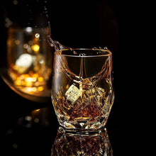 Luxury Bohemian crystal whiskey glass with chilling rocks, showcasing a splash of whiskey and elegant barware.