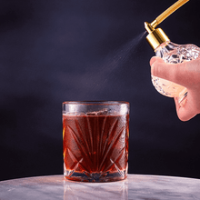 Whiskey glass with cocktail being sprayed, showcasing elegant barware for spirits and cocktail enthusiasts.